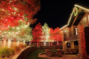 Residential holiday light display with custom roofline and peak lighting.